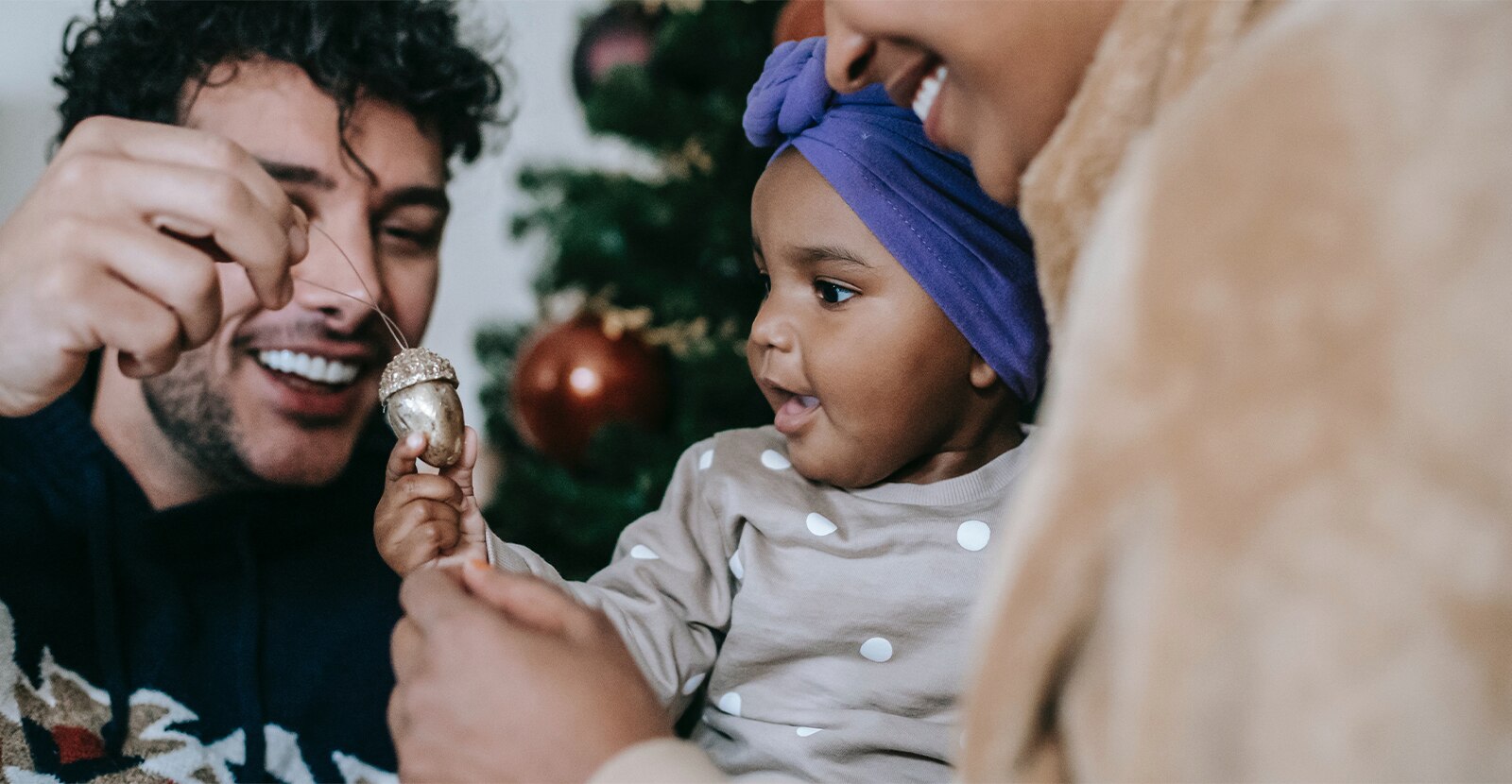 father and young daughter looking at christmas ornament
